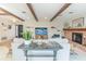 Open concept living room featuring exposed wood beams, a brick fireplace, and stylish décor at 2096 Church Creek Pt, Largo, FL 33774