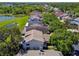 Aerial view showcasing rooftops in a residential neighborhood with mature trees and a serene lake at 2199 Springrain Dr, Clearwater, FL 33763