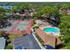 Community featuring tennis courts, a swimming pool, spa, parking, clubhouse, and landscaped areas from an aerial perspective at 2199 Springrain Dr, Clearwater, FL 33763