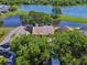 Aerial view of a home with a nearby lake, surrounded by lush greenery and mature trees at 2199 Springrain Dr, Clearwater, FL 33763