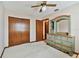 Bedroom with light carpet, wood closet doors, and blue-green painted dresser at 2199 Springrain Dr, Clearwater, FL 33763