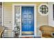 Inviting blue front door with decorative window and well-kept porch with wicker furniture at 2199 Springrain Dr, Clearwater, FL 33763