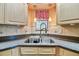 Close-up of kitchen sink with faucet, granite countertop and tile backsplash at 2199 Springrain Dr, Clearwater, FL 33763