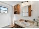 Bathroom featuring wood cabinets, a large mirror, a small window, a bath tub with shower, and neutral walls and decor at 2504 Hawk Griffin Rd, Plant City, FL 33565