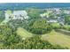 Scenic aerial view of a golf course, a pool with clubhouse and a community near a lake surrounded by lush trees at 25323 Lexington Oaks Blvd, Wesley Chapel, FL 33544