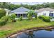 Landscaped backyard with a pond, grass, and privacy at 25323 Lexington Oaks Blvd, Wesley Chapel, FL 33544