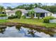 Backyard with lush landscaping, a pond, and a screened-in patio at 25323 Lexington Oaks Blvd, Wesley Chapel, FL 33544