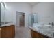 Spacious bathroom featuring double granite countertop sinks, glass-enclosed shower, and walk-in closet at 25323 Lexington Oaks Blvd, Wesley Chapel, FL 33544