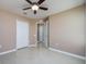 Bedroom with tiled floors, ceiling fan and an open door at 25323 Lexington Oaks Blvd, Wesley Chapel, FL 33544
