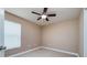 A clean bedroom featuring a ceiling fan, neutral walls, and a bright window at 25323 Lexington Oaks Blvd, Wesley Chapel, FL 33544