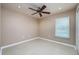 A clean bedroom featuring a ceiling fan, neutral walls, and a bright window at 25323 Lexington Oaks Blvd, Wesley Chapel, FL 33544
