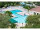 Aerial view of an expansive community pool featuring ample lounge chairs, shaded area, and mature trees at 25323 Lexington Oaks Blvd, Wesley Chapel, FL 33544