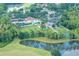 Scenic aerial view of a community pool, playground, and sports courts near a pond surrounded by lush trees at 25323 Lexington Oaks Blvd, Wesley Chapel, FL 33544