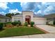 Charming single-story home featuring a well-manicured lawn and colorful landscaping at 25323 Lexington Oaks Blvd, Wesley Chapel, FL 33544