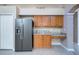 Well-lit kitchen featuring stainless steel refrigerator, granite countertops, and wooden cabinets at 25323 Lexington Oaks Blvd, Wesley Chapel, FL 33544