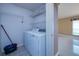Laundry room with washer, dryer, wire racks, and tile flooring at 25323 Lexington Oaks Blvd, Wesley Chapel, FL 33544
