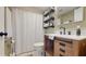 Updated bathroom featuring rustic vanity with granite countertop, shower and modern shelving at 2572 Forest Run Ct, Clearwater, FL 33761