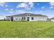 Wide backyard features lush green lawn, home's rear elevation, and a screened lanai at 2832 Marrakesh Ln, Sarasota, FL 34234