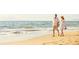 A couple strolling hand-in-hand along a pristine sandy beach with gentle waves at 2832 Marrakesh Ln, Sarasota, FL 34234