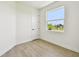 Cozy bedroom featuring neutral paint, light wood flooring, and a window with views of the outdoors at 2832 Marrakesh Ln, Sarasota, FL 34234