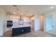 Stylish kitchen featuring a dark island, white cabinetry, stainless steel appliances, and modern pendant lights at 2832 Marrakesh Ln, Sarasota, FL 34234
