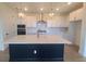 Modern kitchen with white countertops, dark blue island, stainless steel appliances, and decorative pendant lights at 2832 Marrakesh Ln, Sarasota, FL 34234