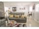 Modern living room featuring a grey reclining sofa, coffee table, and dining area in an open layout at 314 E Althea Ave, Tampa, FL 33612