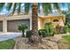 Inviting exterior showcasing a well-kept lawn, landscaping, and mature palm trees framing the home's facade at 31833 Turkeyhill Dr, Wesley Chapel, FL 33543