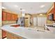 Practical kitchen featuring wood cabinets, white countertops, stainless steel appliances, and a layout that flows into the laundry area at 31833 Turkeyhill Dr, Wesley Chapel, FL 33543