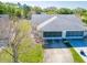 Aerial view of a single-Gathering home with a well-maintained lawn and a large driveway at 3346 Gorse Ct, Palm Harbor, FL 34684
