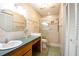 Well-lit bathroom with a glass shower, tiled walls, and a vanity with a countertop and mirror at 3346 Gorse Ct, Palm Harbor, FL 34684