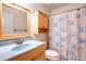 Well-maintained bathroom with a wooden vanity, seashell shower curtain, and functional built-in storage at 3346 Gorse Ct, Palm Harbor, FL 34684