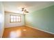 Bright bedroom featuring laminate flooring, a ceiling fan, and a window with wooden shutters providing natural light at 3346 Gorse Ct, Palm Harbor, FL 34684