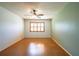 Light-filled bedroom featuring wood-look flooring, a ceiling fan, and a window with wooden shutters at 3346 Gorse Ct, Palm Harbor, FL 34684