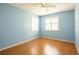 Cozy blue bedroom featuring wood laminate flooring, two white shuttered windows, and ample natural light at 3346 Gorse Ct, Palm Harbor, FL 34684