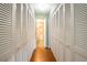 Long hallway of louvered closets with a view of the adjoining bathroom, providing abundant storage space at 3346 Gorse Ct, Palm Harbor, FL 34684
