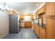 Well-lit kitchen with stainless steel refrigerator, matching appliances, and blue tile flooring at 3346 Gorse Ct, Palm Harbor, FL 34684