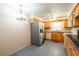 Bright kitchen boasts stainless steel refrigerator, wood cabinets, and modern appliances at 3346 Gorse Ct, Palm Harbor, FL 34684