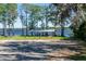Scenic lake view with covered picnic structure and mature trees casting shadows on the grassy shoreline at 3346 Gorse Ct, Palm Harbor, FL 34684