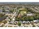 Scenic aerial view of a residential community with green spaces, a pond, and mature trees at 3352 Honeymoon Ln, Holiday, FL 34691