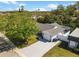 Aerial view of home showing long driveway, mature landscaping, and two-car garage at 3352 Honeymoon Ln, Holiday, FL 34691