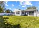 Expansive backyard featuring a well-manicured lawn, white fence, and patio at 3352 Honeymoon Ln, Holiday, FL 34691