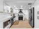 Bright kitchen features white cabinets, stainless steel appliances, modern fixtures and light hardwood flooring at 3352 Honeymoon Ln, Holiday, FL 34691