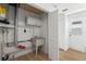 Functional laundry room with utility sink, storage, and access to the backyard at 3352 Honeymoon Ln, Holiday, FL 34691