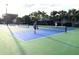 Active pickleball game on a well-maintained court surrounded by lush greenery at 4594 Mohican Trl # 143, Sarasota, FL 34233