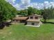 An aerial view showing a well-manicured lawn and surrounding trees, providing privacy at 4902 Five Acre Rd, Plant City, FL 33565