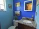 Bright blue bathroom featuring granite countertops, light wood cabinets, and themed decor at 4902 Five Acre Rd, Plant City, FL 33565