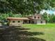 Charming two-story home with a well-maintained lawn and mature trees providing shade at 4902 Five Acre Rd, Plant City, FL 33565
