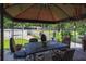 Enjoy outdoor dining under this covered gazebo with a grill and a view of the yard at 4902 Five Acre Rd, Plant City, FL 33565