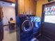 Laundry room with front loading washer and dryer and wooden cabinets above at 4902 Five Acre Rd, Plant City, FL 33565